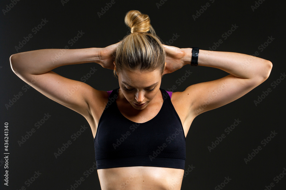 Obraz premium Young beautiful sport woman at studio on black background