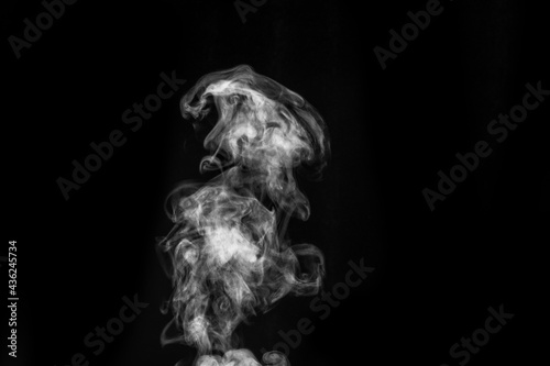 Perfect mystical curly white steam or smoke isolated on black background. Abstract background fog or smog, design element for Halloween, layout for collages. © Alena
