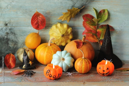 Happy Halloween, pumpkins, Jack lantern with a burning candle, autumn leaves and mystical decorations on a wooden background