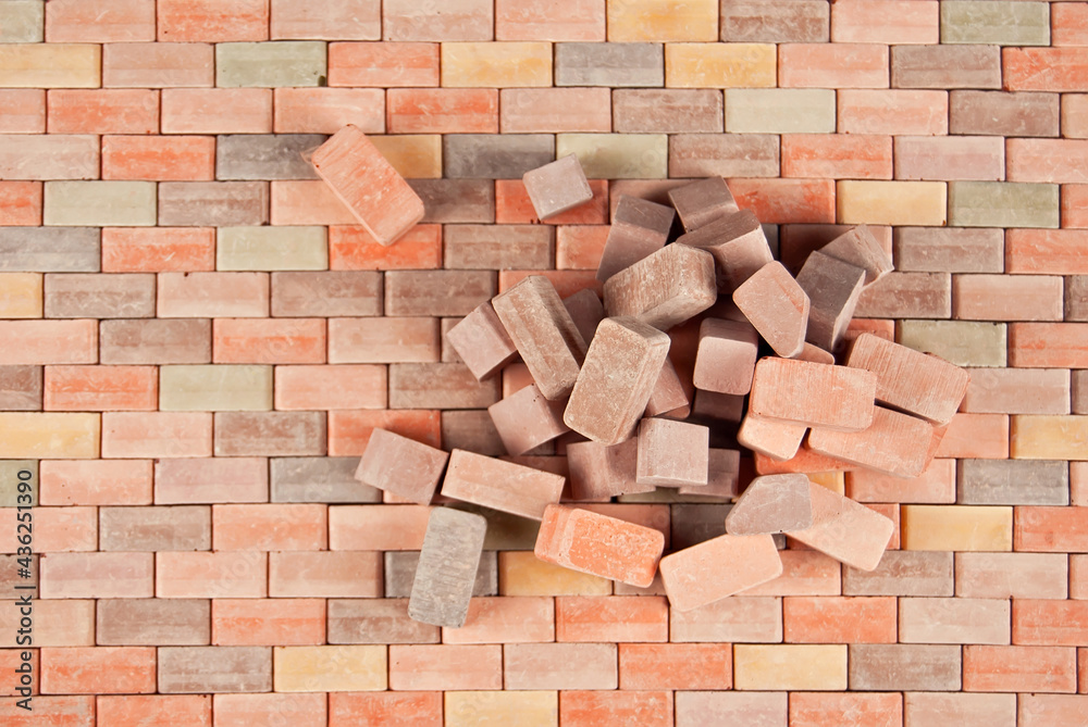 Fototapeta premium Colorful bricks on a pile. Brick texture close up. The blocks are stacked on brick paving.