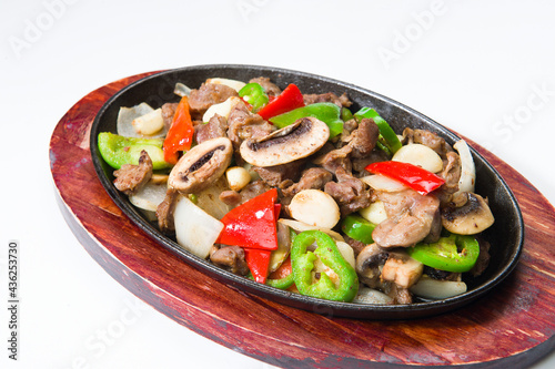 Asian beef with red peppers and mushrooms at a Korean restaurant.  White background.  .........
