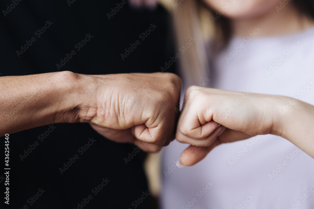 Multiethnic couple hands making fist bump. Young Caucasian woman and African male embracing and smiling at home. Family Success concept