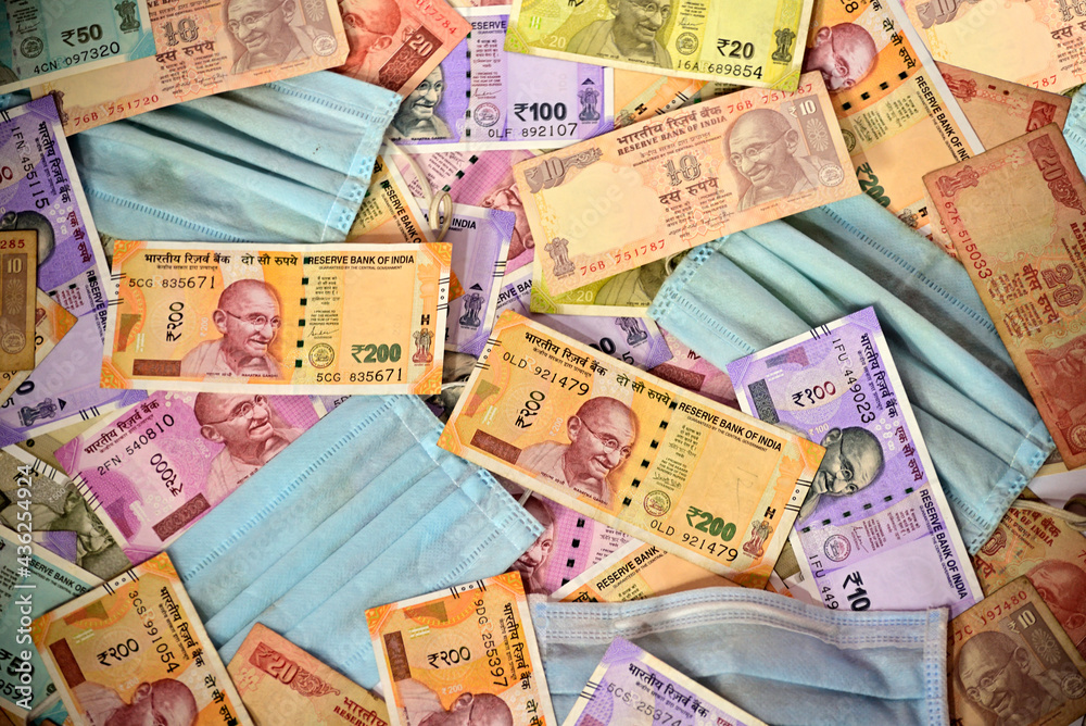 Protective face mask and Indian paper currency as a background Protective face mask and Indian paper currency as a background