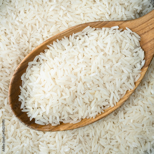 long-grain polished rice in wooden spoon closeup