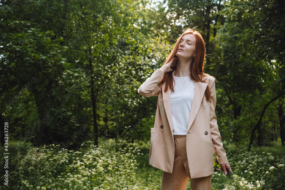 Stress and resilience. Spend Time in Nature to Reduce Stress and Anxiety. Nature break relieves stress. Young woman in suit enjoying nature and walking in green summer park Stress and resilience. Spend Time in Nature to Reduce Stress and Anxiety. Nature break relieves stress. Young woman in suit enjoying nature and walking in green summer park