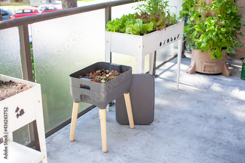 Foto A vermicomposting system (worm composter) sits on an apartment balcony with other patio planters
