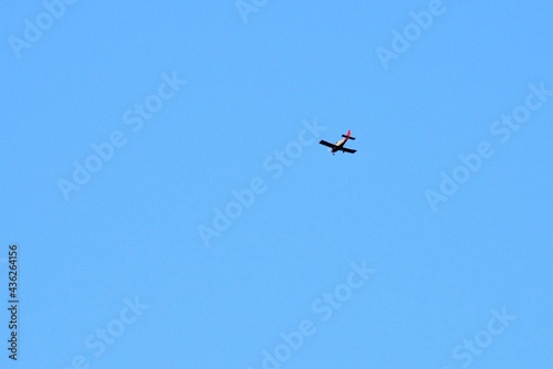 Against the background of a huge blue spring sky, we see a flying plane