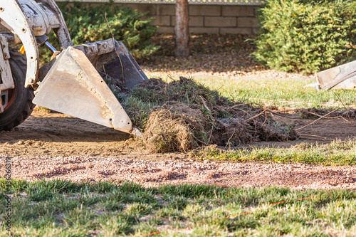 Fotografija Small Bulldozer Removing Grass From Yard Preparing For Pool Installation