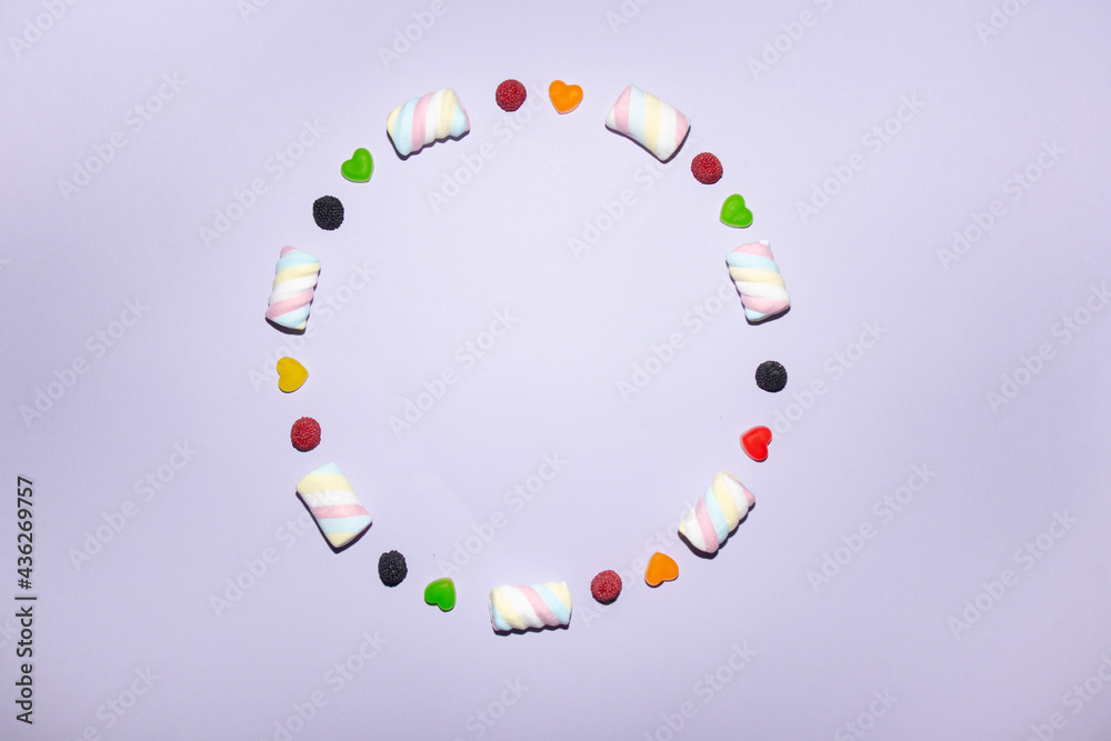 Coloured frame circle made of various tasty candies, interesting concept, flat lay style.