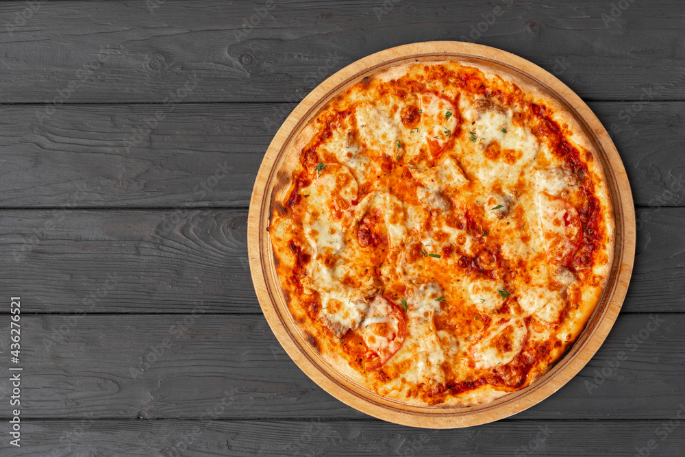 Tasty pizza on black wooden background top view