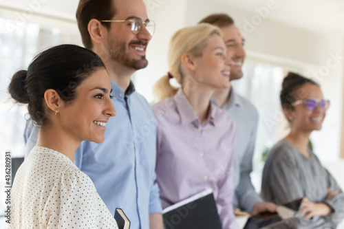 Close up happy diverse motivated employees team standing in office, smiling successful confident workers coworkers or interns looking to aside, positive excited business people staff department photo