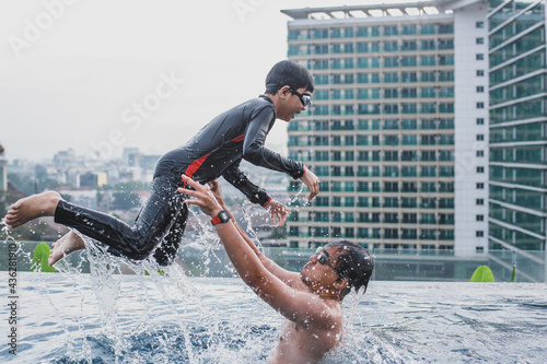 Father playing with his son in the swimming pool