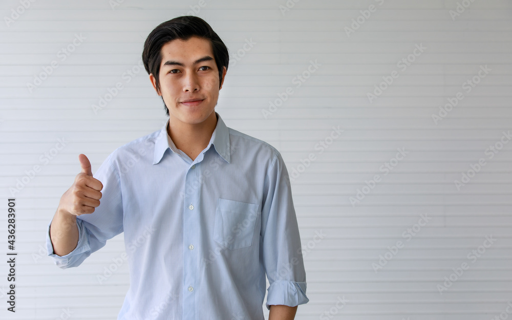 20s handsome professional successful business working man or employee wearing formal shirt, smiling with happiness and satisfaction, making gesture great thumb up, standing indoor office or workplace. 20s handsome professional successful business working man or employee wearing formal shirt, smiling with happiness and satisfaction, making gesture great thumb up, standing indoor office or workplace.