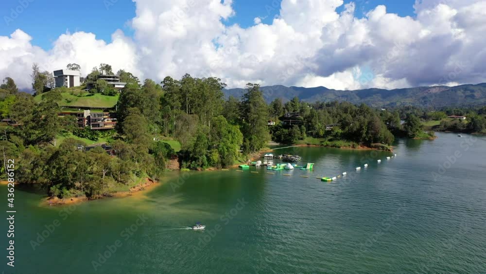 Aerial Descending Shot Of Boat Moving In Sea By Trees, Drone Flying Over Tourist During Vacation - Guatape, Colombia Aerial Descending Shot Of Boat Moving In Sea By Trees, Drone Flying Over Tourist During Vacation - Guatape, Colombia