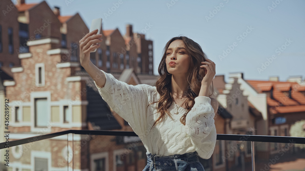 young woman taking selfie and pouting lips.