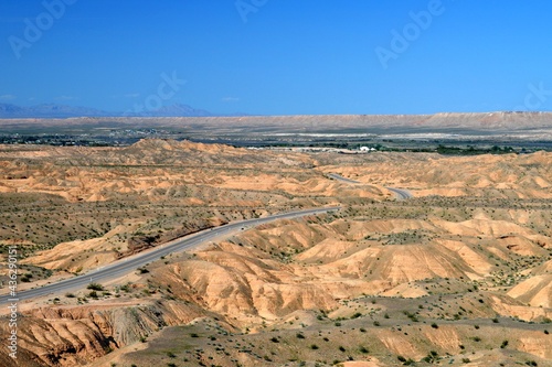 The empty, desolate road winding through the desert landscape on the outskirts of Logandale Clark County Nevada. photo