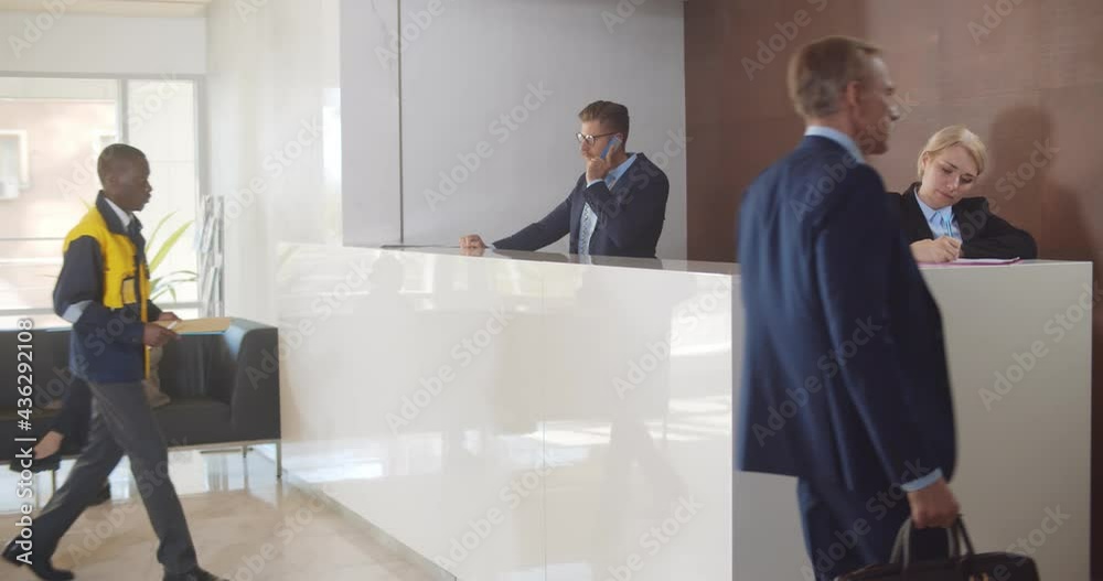 Man secretary signing for delivered padded envelope at reception desk in office building