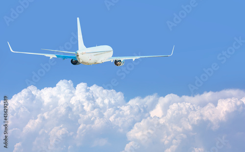 White passenger airplane over the clouds - Travel by air transport