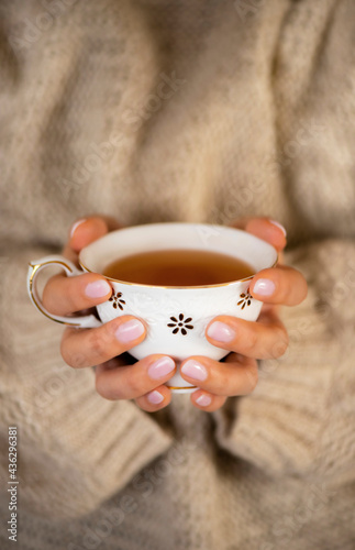 A cup of tea with hands photo