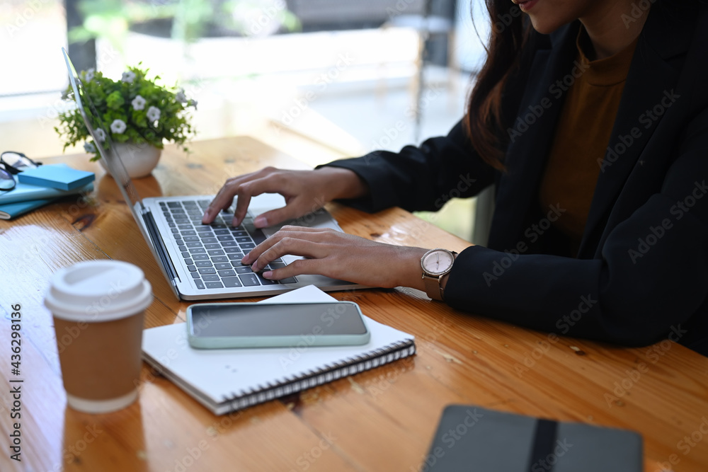 Cropped shot of businesswoman typing on keyboard while sitting in her office room. Cropped shot of businesswoman typing on keyboard while sitting in her office room.