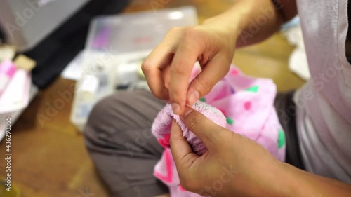 Detail video of woman sewing.