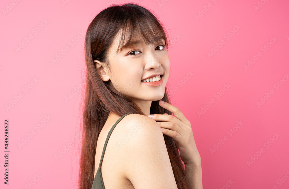 Portrait of a beautiful young asian girl posing on a pink background Portrait of a beautiful young asian girl posing on a pink background