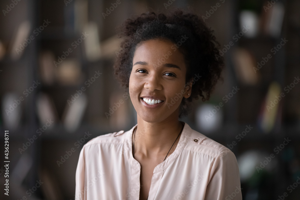 Head shot portrait of sincere smiling attractive millennial generation mixed race african woman looking at camera, holding video call online zoom meeting, professional blogger shooting video. Head shot portrait of sincere smiling attractive millennial generation mixed race african woman looking at camera, holding video call online zoom meeting, professional blogger shooting video.