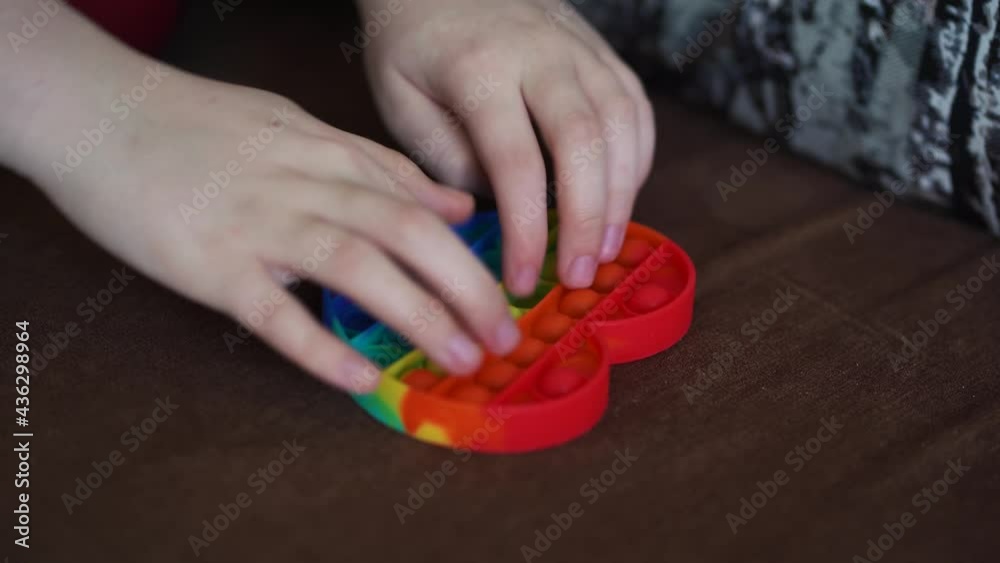 child playing with toy pop it simple dimple close up heart shaped on sofa child playing with toy pop it simple dimple close up heart shaped on sofa