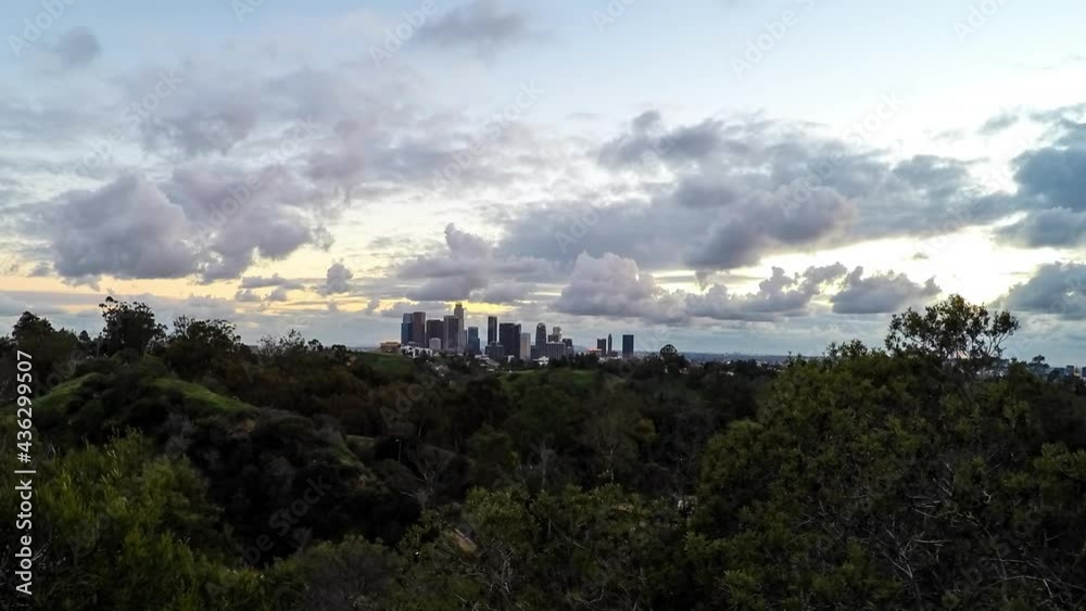 Lockdown Time Lapse Shot Of Trees Against Modern Buildings In City Against Cloudy Sky During Sunset - Los Angeles, California Lockdown Time Lapse Shot Of Trees Against Modern Buildings In City Against Cloudy Sky During Sunset - Los Angeles, California