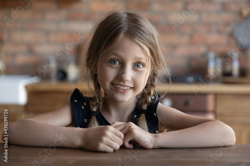 Happy cute blogger girl looking at web camera, speaking and smiling. Screen view of pre teen kid using digital device for video call or watching online virtual conference event, streaming online. Head