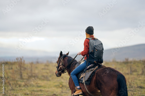 woman with backpack riding horse nature walk friendship