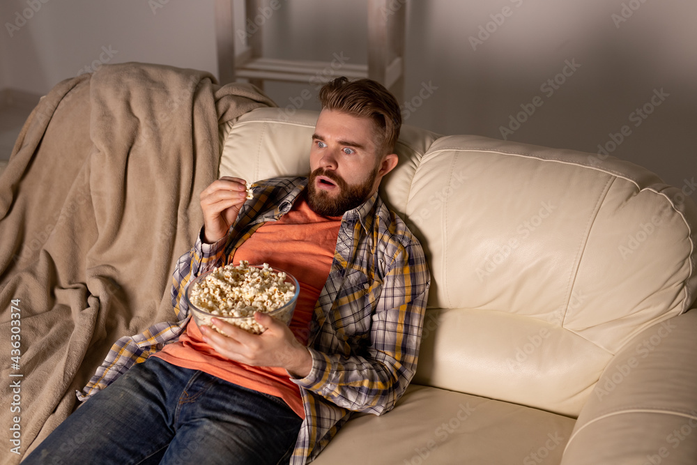 Single man on the couch watching TV Single man on the couch watching TV