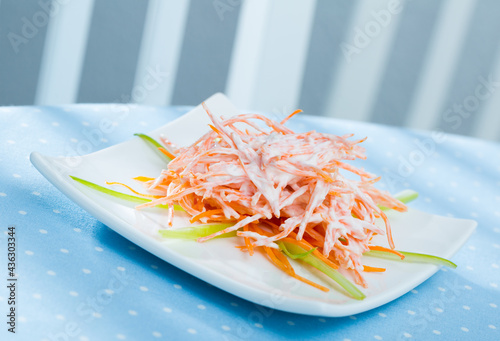 Healthy fresh carrot salad with sour cream and garlic served on white plate.. photo