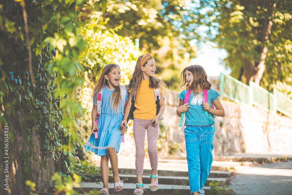 Fototapeta premium Three little girls going to school.