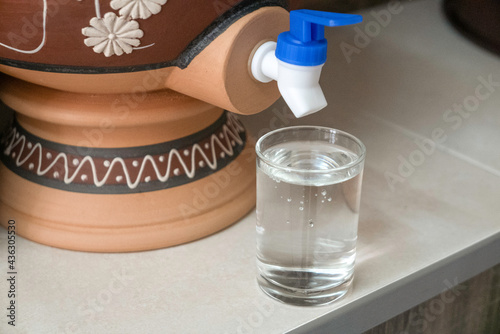 A glass of water from traditional water dispenser called Labu Sayong (water calabash) in Malay language.