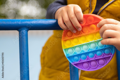 anti-stress anti-anxiety popular toy anti-stress bubbles pop it simple dimple multicolored heart shape in the hands of a child on the street play