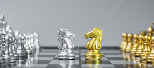 Gold and silver Chess Knight (horse) figure on Chessboard against opponent or enemy. Strategy, Conflict, management, business planning, tactic, politic, communication and leader concept