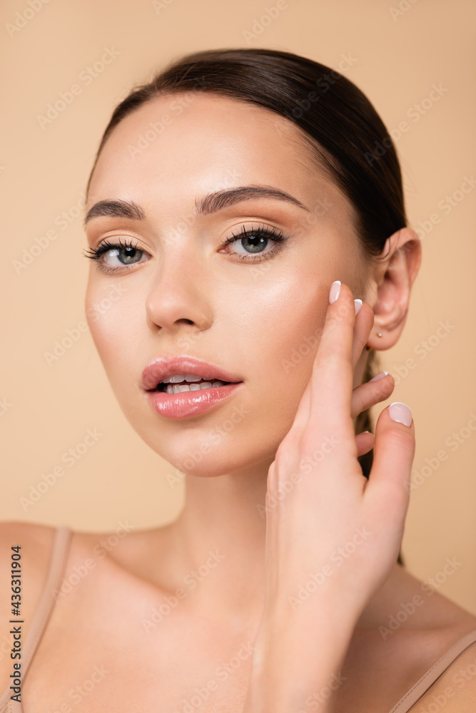 pretty woman with natural makeup looking at camera isolated on beige. pretty woman with natural makeup looking at camera isolated on beige.