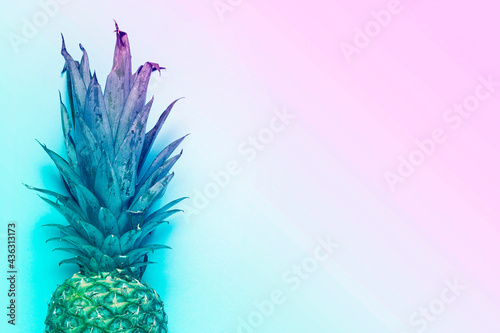 whole ripe pineapple on a blue background. Added color gradient. Top view  flat lay