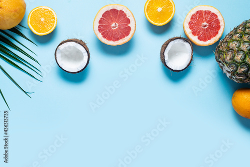 Fototapeta Naklejka Na Ścianę i Meble -  exotic fruits on blue. Pineapple, coconut, orange, grapefruit. Top view, flat lay