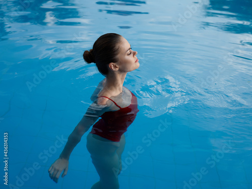 woman swim in transparent pool water naked shoulders red swimsuit model