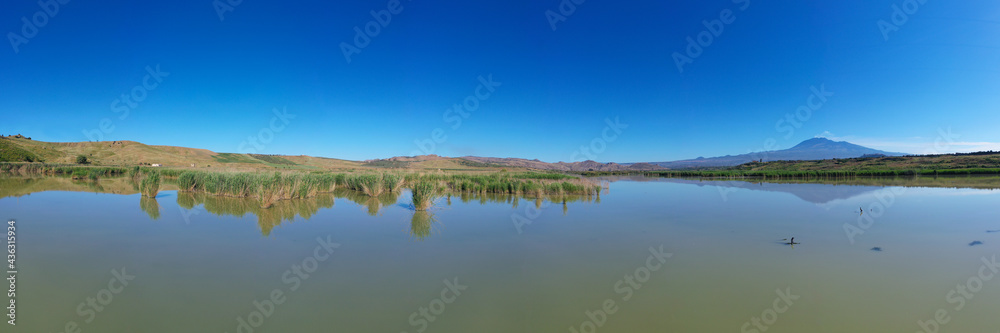 180 degrees aerial photo of the Oasis of Ponte Barca a protected area in the heart of Paternò in Sicily. Wetland that attracts numerous waterfowl. Nesting place of the Sultan chicken. Etna view.