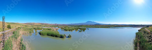 180 degrees aerial photo of the Oasis of Ponte Barca a protected area in the heart of Paternò in Sicily. Wetland that attracts numerous waterfowl. Nesting place of the Sultan chicken. Etna view.