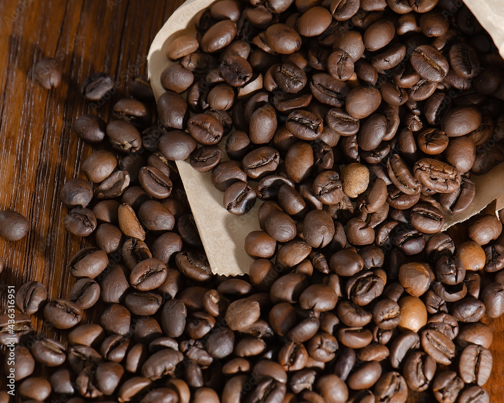 Obraz premium Roasted coffee beans in a paper bag. Close-up. View from above