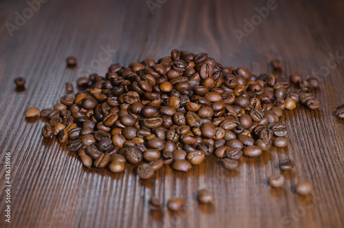 Grains of black coffee lie on a wooden table