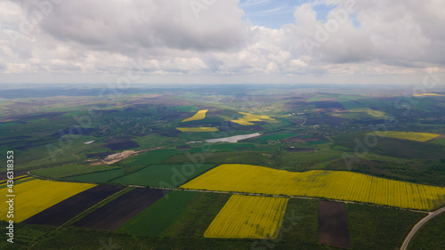 Agriculture aerial view with green fields and yellow fields with rapeseed from above. Photo from drone.