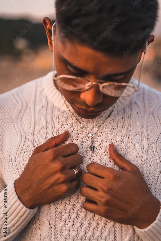 Summer lifestyle, a young Latino enjoying summer vacations. dressed in white with pants and sweater, detail of the hands Summer lifestyle, a young Latino enjoying summer vacations. dressed in white with pants and sweater, detail of the hands