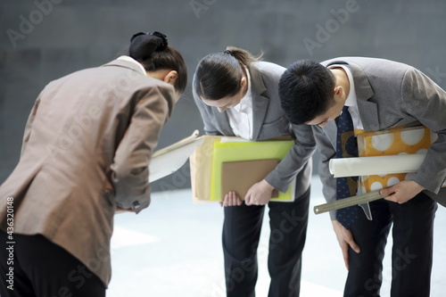 Business people taking bow in corridor