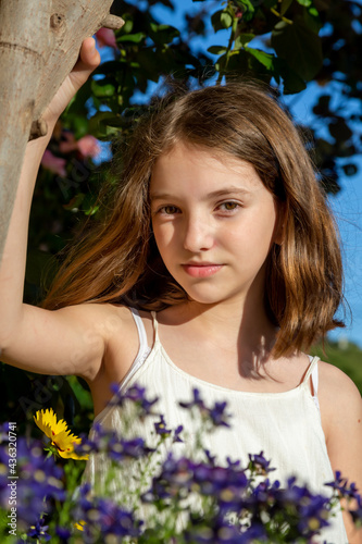 Beautiful emotional natural cute teenager girl with flowers on a sunny day