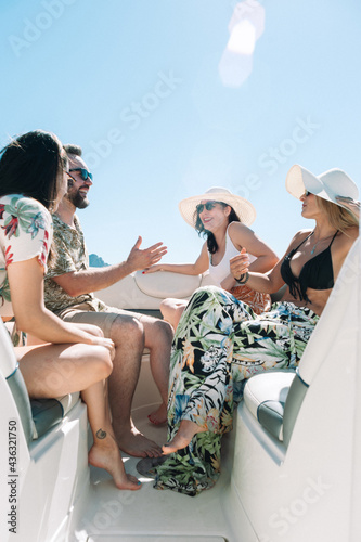 Smiling friends sitting on sailboat deck and having fun.Vacation, travel, sea, friendship and people concept